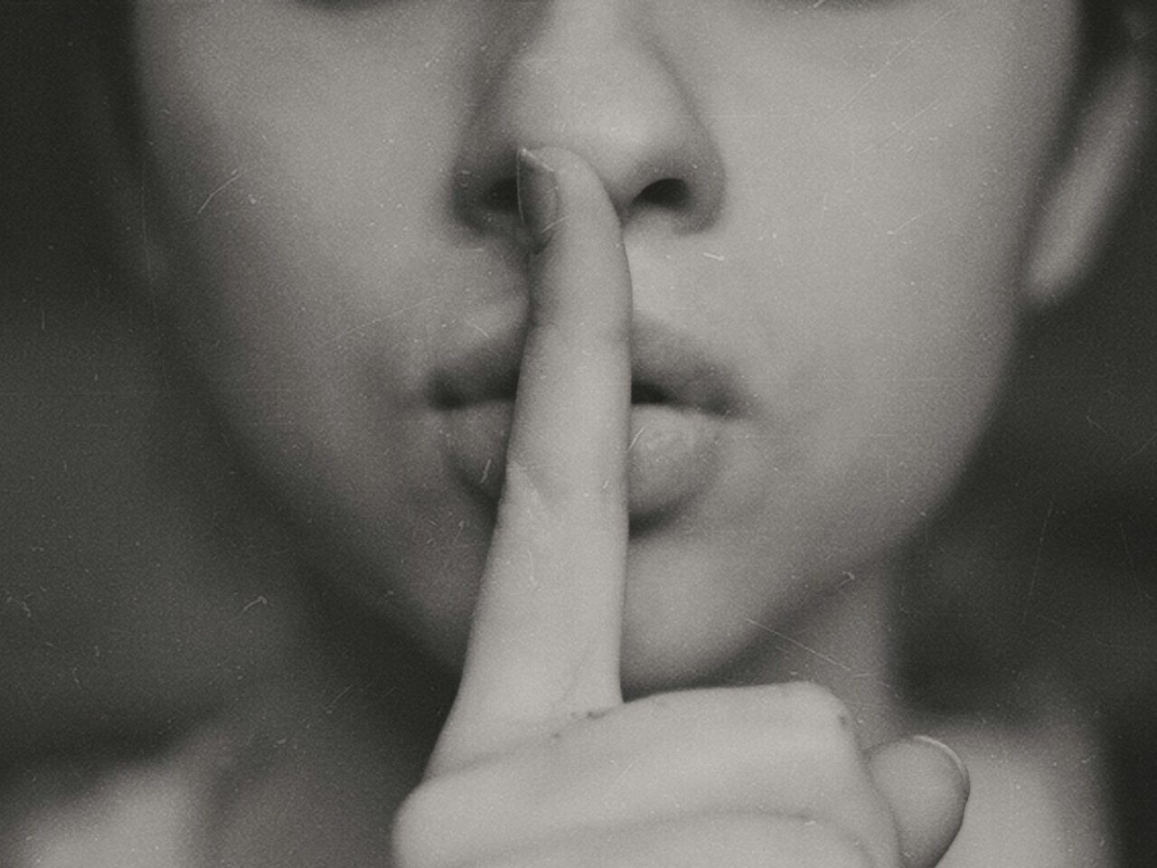 grayscale photo of woman doing silent hand sign
