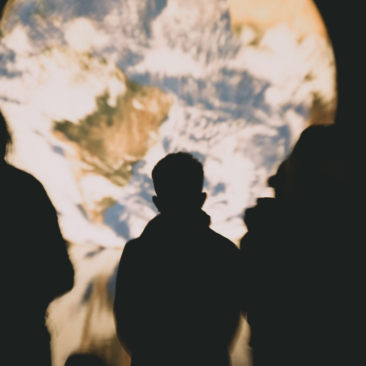 People observe a projection of earth.