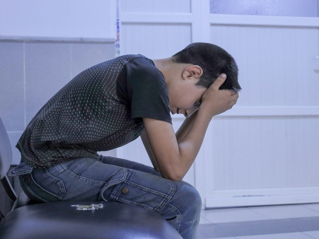 A man sitting on a chair with his head in his hands