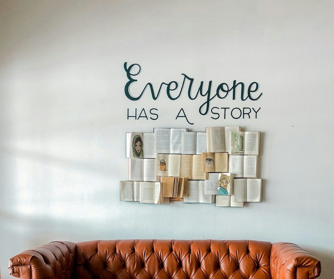 a brown leather couch sitting in front of a white wall