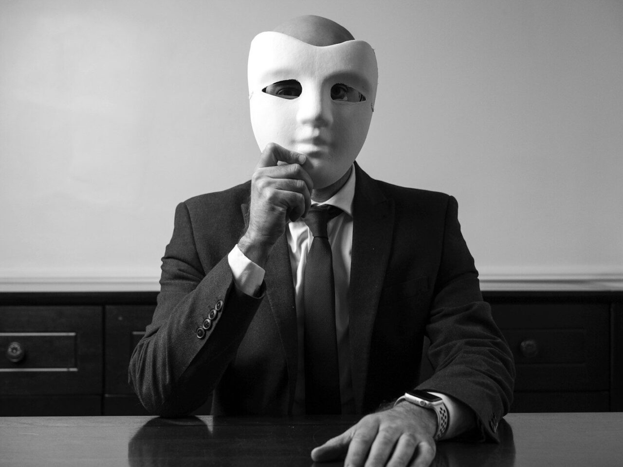 A man sitting at a table with a mask on his face
